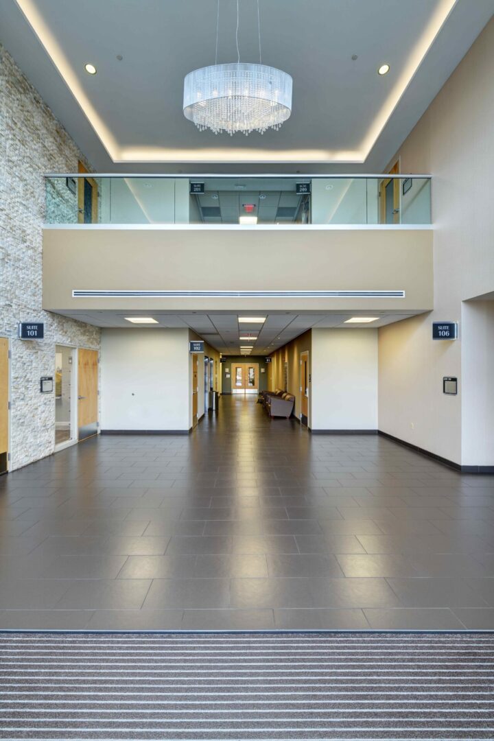 A large hallway with two floors and a glass railing.