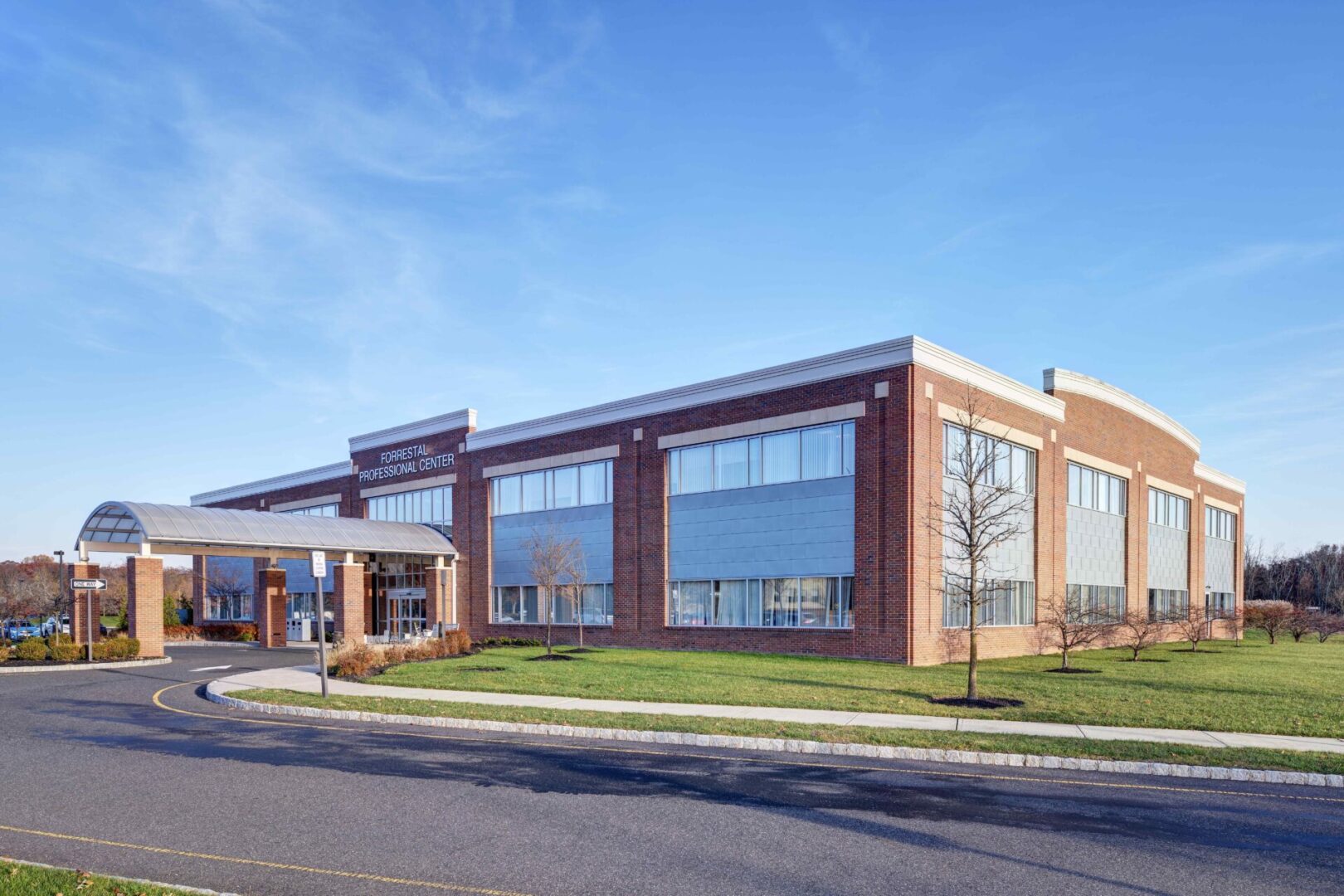 A large brick building with a green lawn in front of it.