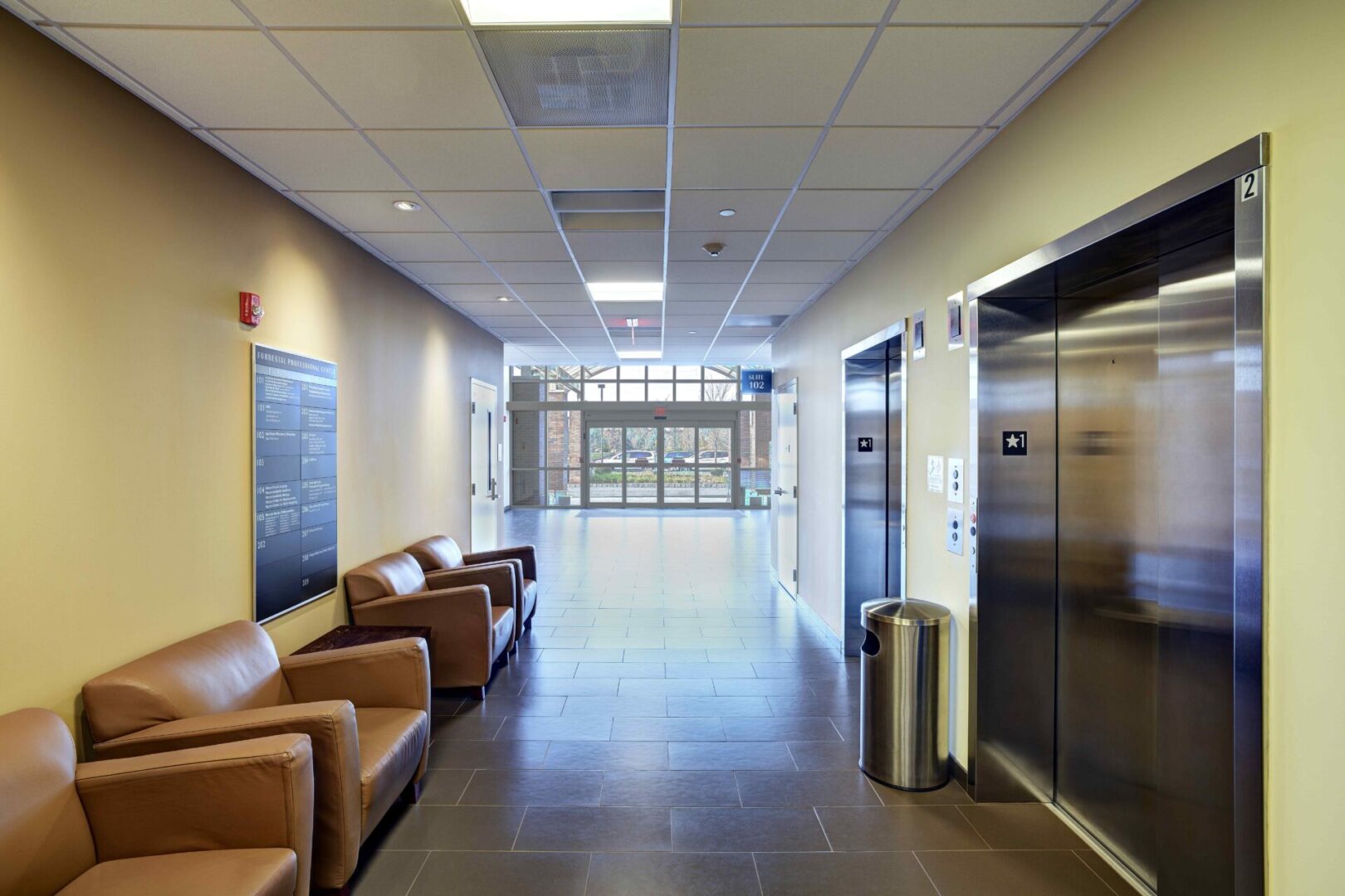 A hallway with several chairs and a door.