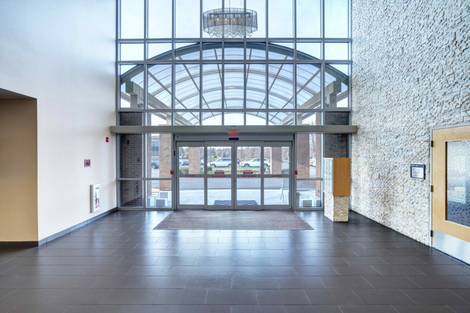 A large glass building with a door open.