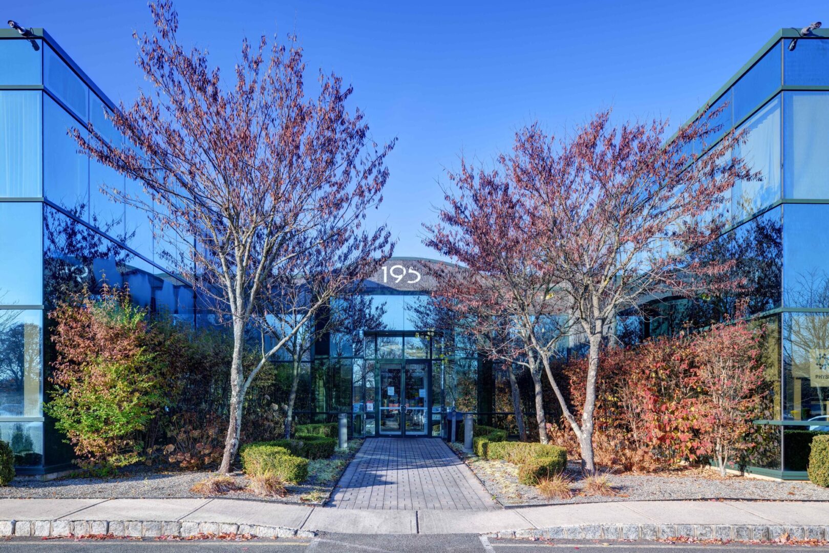 A building with trees and bushes in front of it.