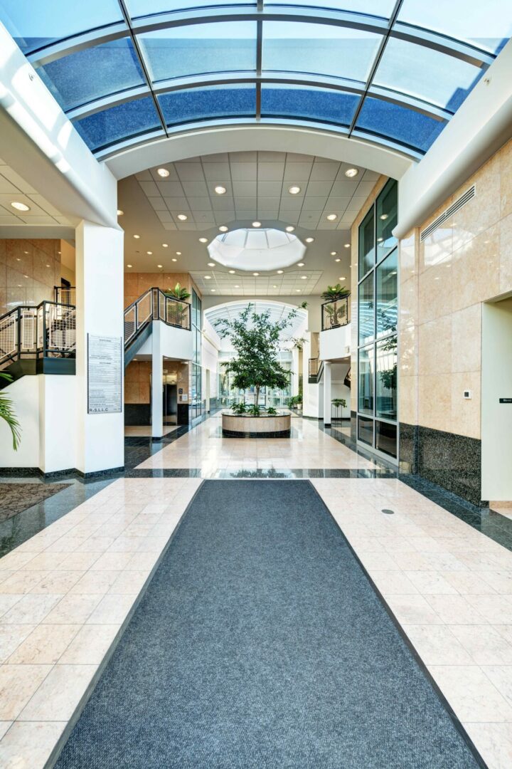 A hallway with a black carpet and white walls.