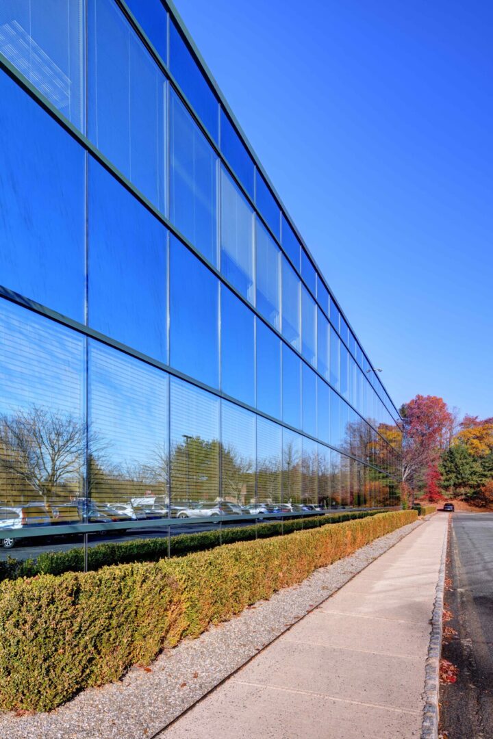 A building with many windows reflecting the sky.