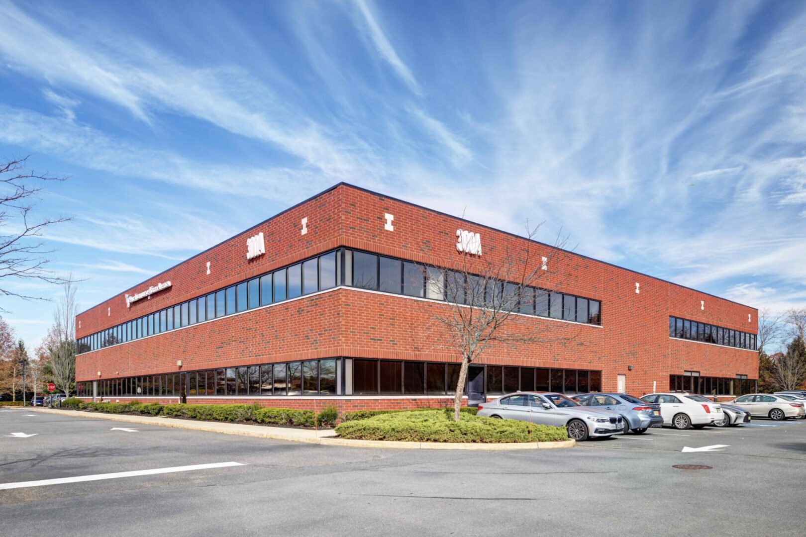 A large brick building with cars parked in front of it.