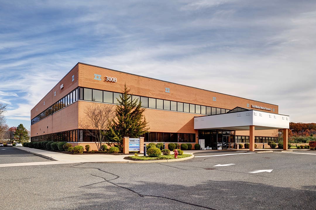 A large brick building with trees in front of it.