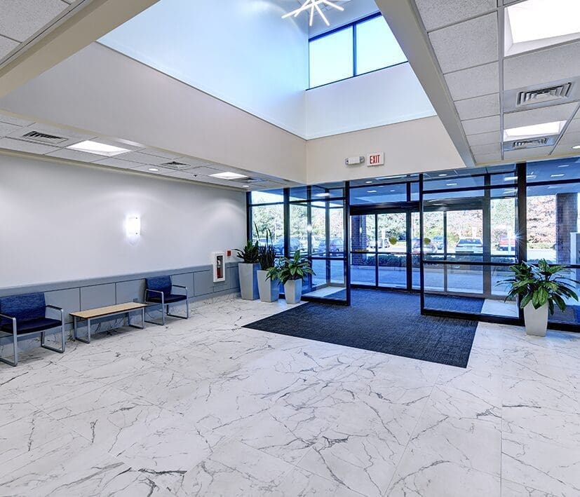 A lobby with benches and a large glass door.